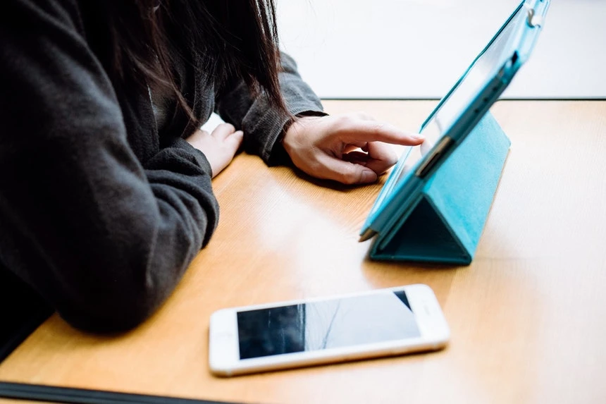 A Woman Looking At Her Electronic Resume In Her Tablet