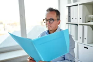 Businessman With Folder And Papers At Office