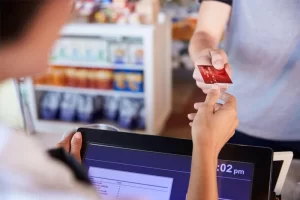 Cashier Accepts Card Payment From Customer