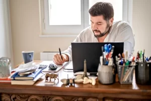 An It Director Writing Notes During Virtual Meeting