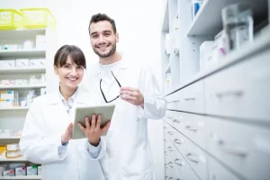 Portrait Of Two Smiling Pharmacists With Tablet