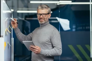 An Expert Product Manager Devising New Marketing Plans On A White Board