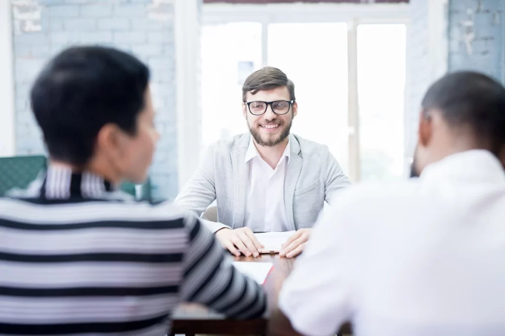 Applicant Confidently Smiling During An Interview Having Full Knowledge Of How Long Do First Job Interviews Last