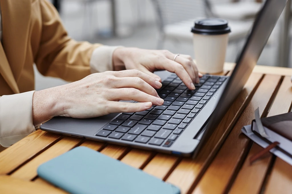 Closeup Of A Job Seeker Working On His Resume Using A Laptop