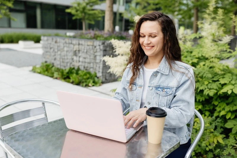 A Woman Writing Her Staff Accountant Resume Using A Laptop