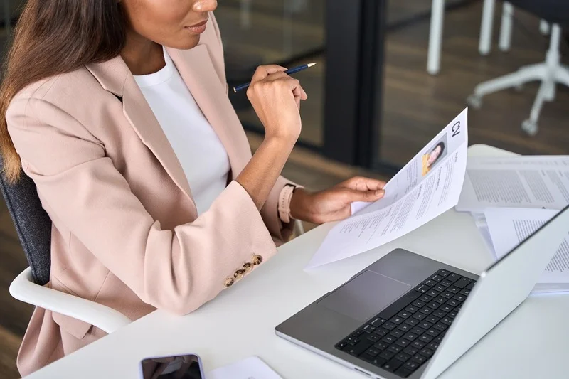 An Hr Manager Reviewing An Applicants Video Resume While Holding His Cv