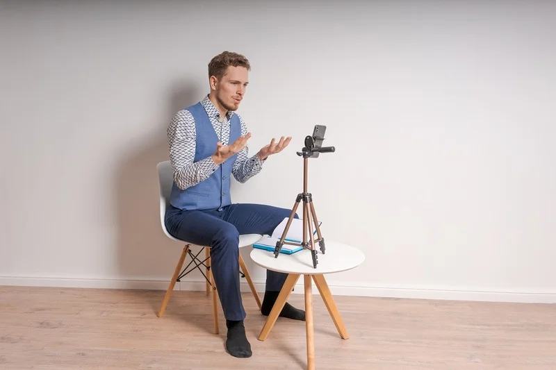 An Applicant Recording Himself While His Video Resume Script Is Placed Nearby For Reference