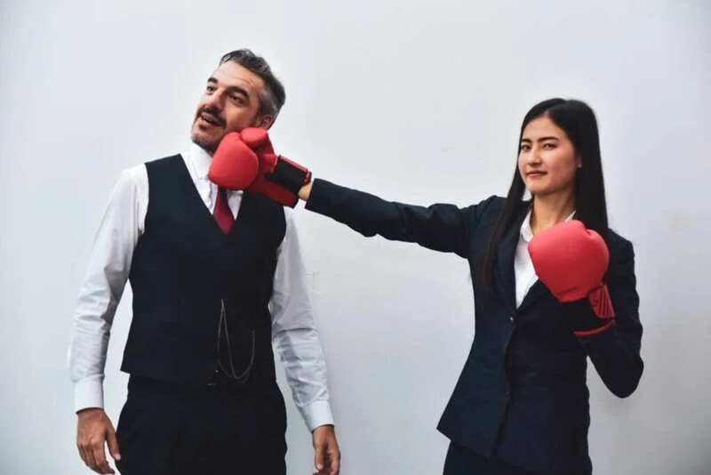 Office Worker Wearing Boxing Gloves Punching Her Colleague Depicting Workplace Bullying 1024X683 1