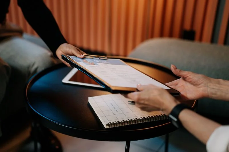 Person In Black Long Sleeve Shirt Writing On White Paper