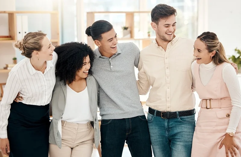 Smiling Group Of Employees Demonstrating An Effective Hybrid Workplace Strategy