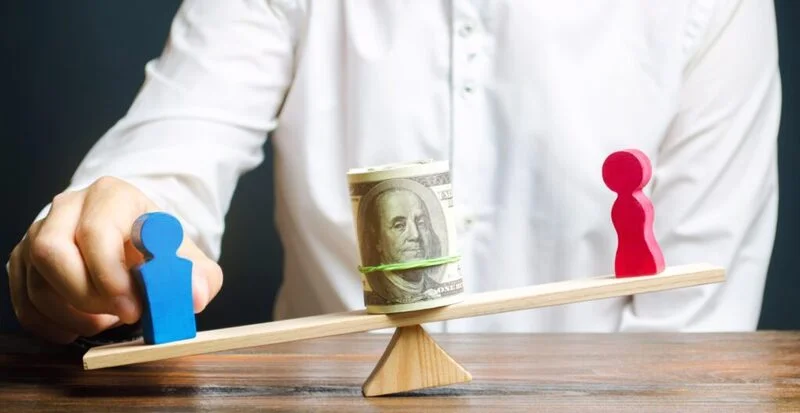 Wooden Figures Of Man And Woman On Scales Depicting Workplace Inequality 1024X528 1