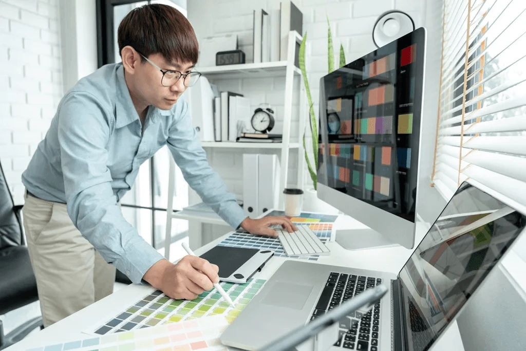 Busy Graphic Designer Using Multiple Computers