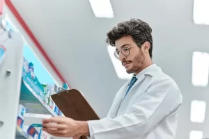 Pharmacist Documenting The Shelves Of Medications