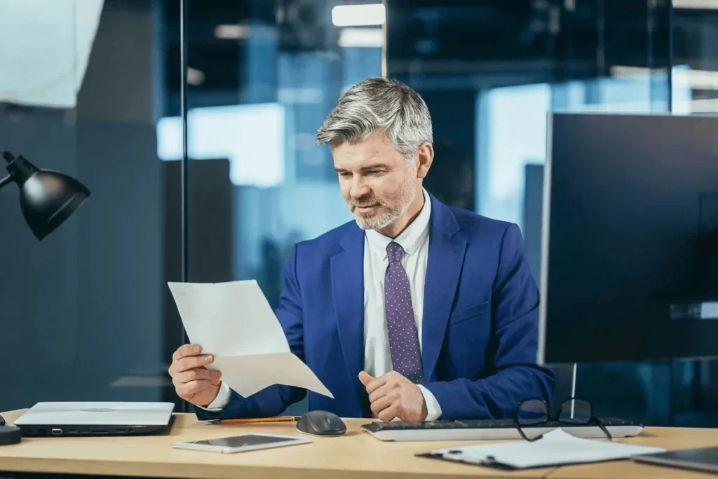 Manager Reading An Excuse Letter From An Absent Employee