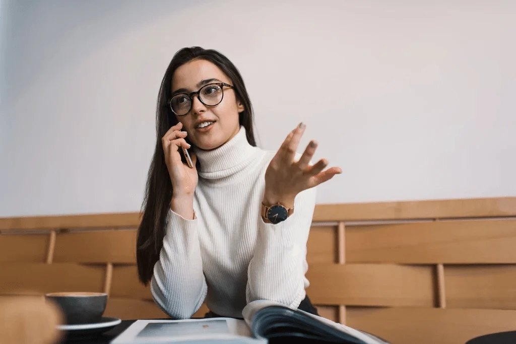 A Job Applicant Talking On A Phone In Cafe For A Phone Interview