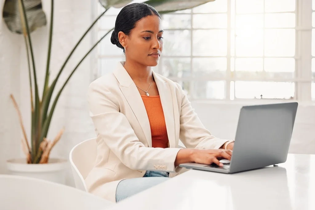 A Woman Typing A Summary Of Her 
Resume