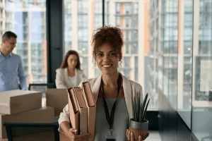 career changer smiling while carrying her office stuff