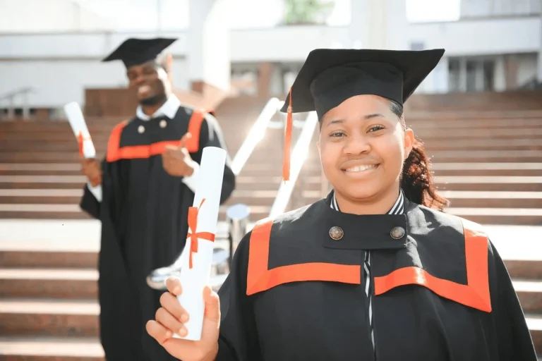 communications degree graduate holding their diploma