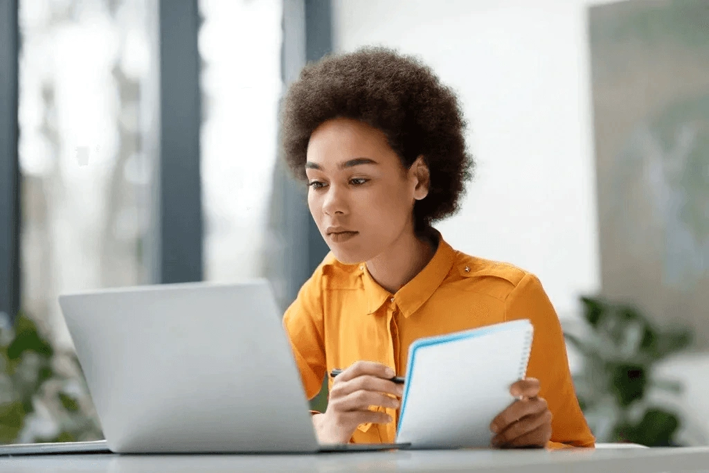 Female Applicant Researching Tips About Proper Questions To Ask At The End Of An Interview