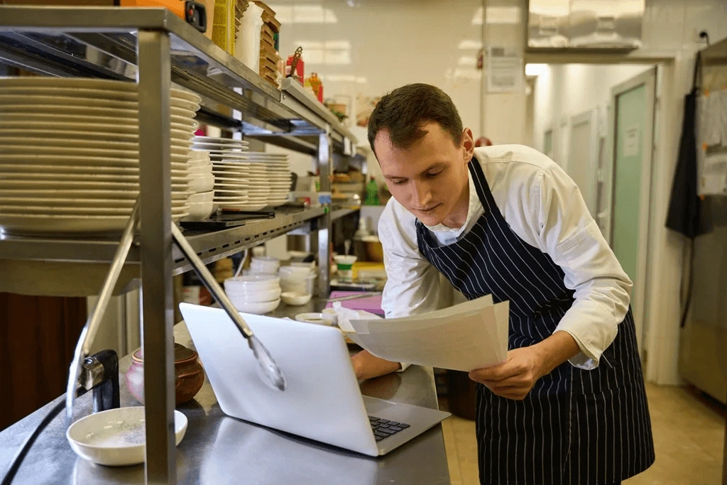 Male Restaurant Crew Researching On His Laptop About Waiter Resume Samples