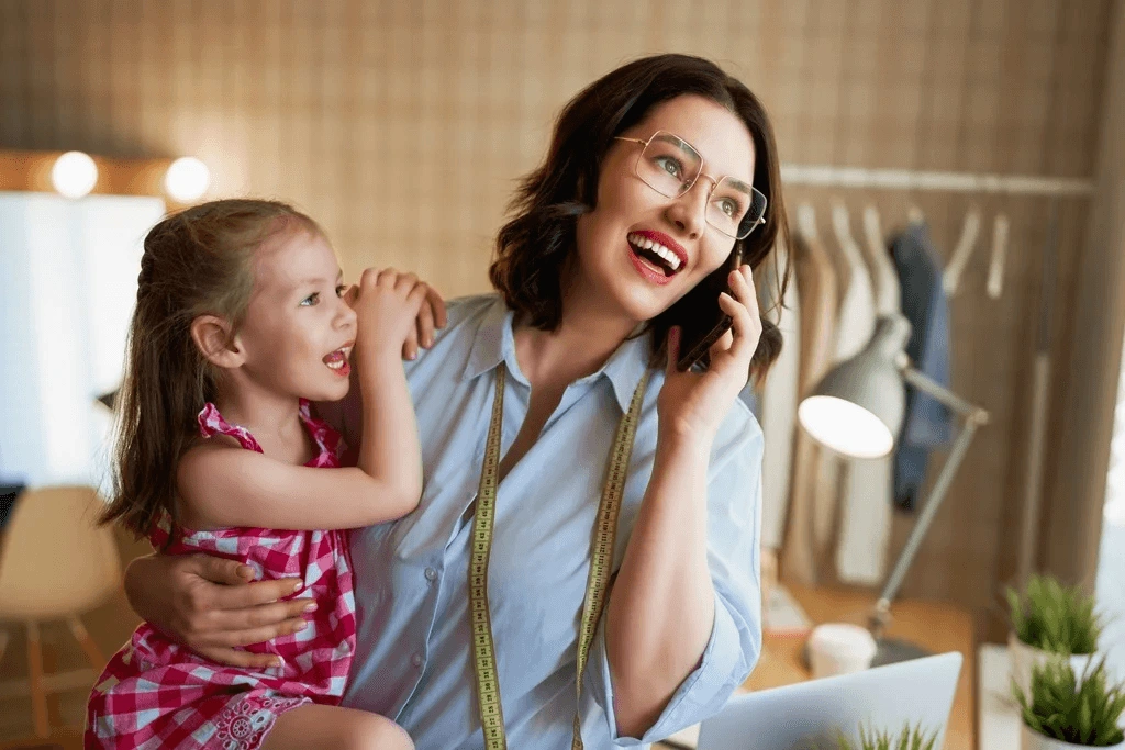 Mother Answering Call From Client While Holding Her Daughter