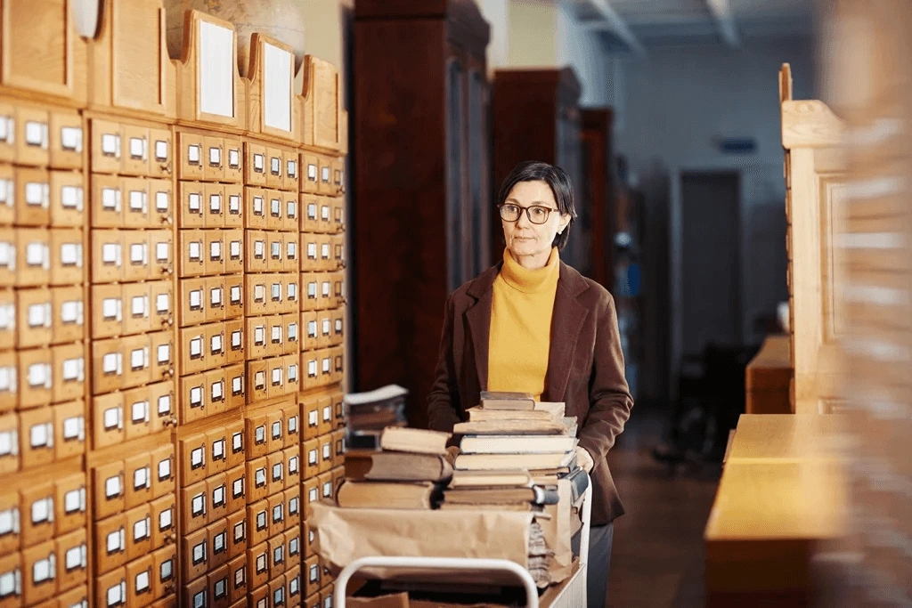 Old Clerk Sorting Out Books In The Library