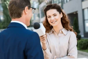 public relations officer attentively interviewing a person