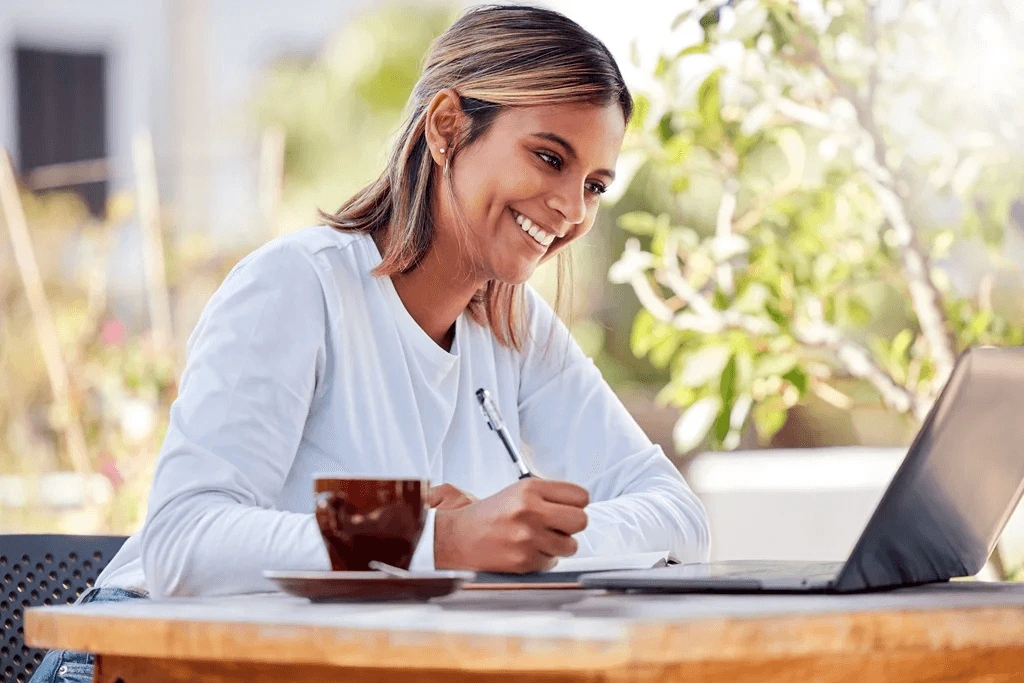 Woman Happily Writes An Effective Letter In An Outdoor Cafe