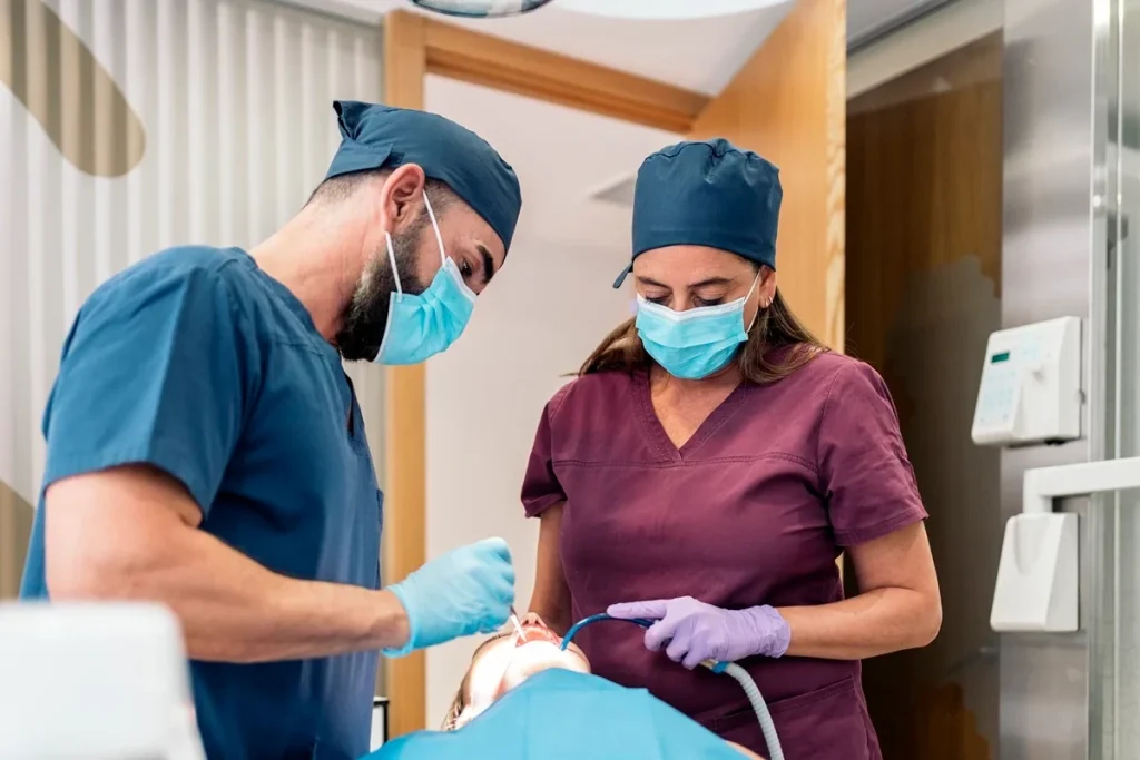 Dental Assistant Working Alongside A Licensed Dentist