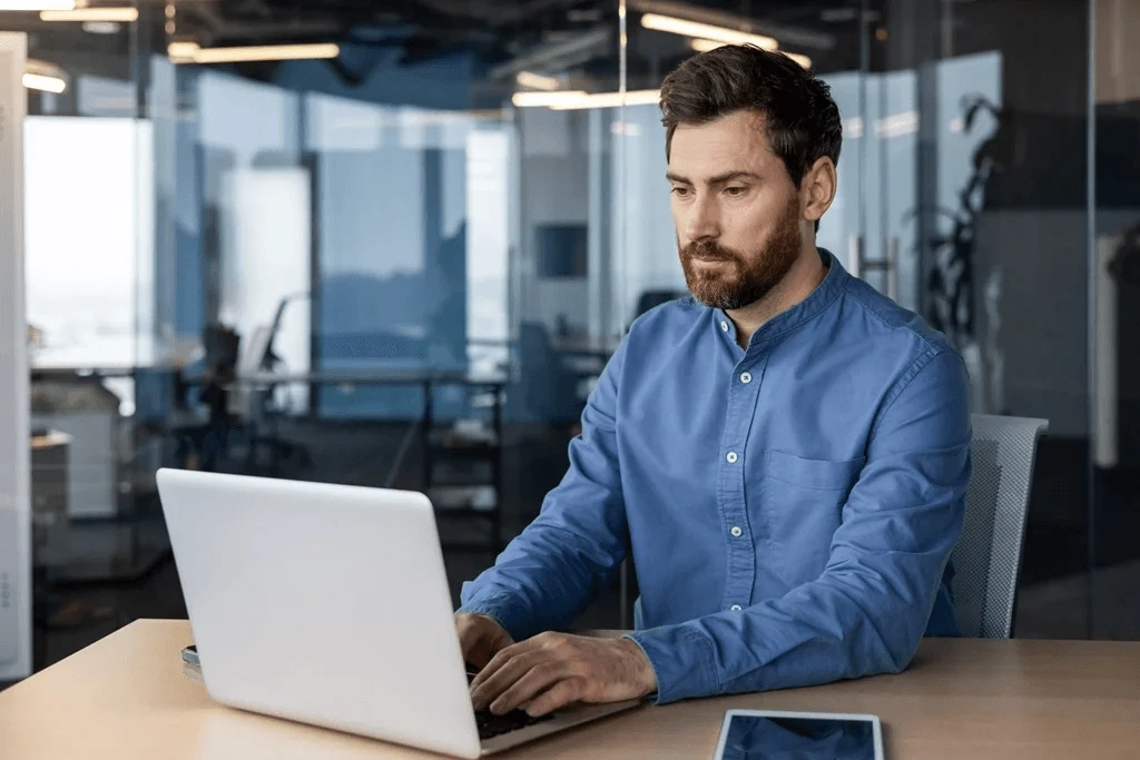 Employee Seeking Project Manager Career Advice Using His Laptop