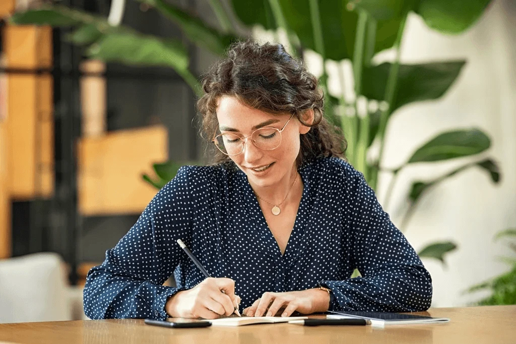 Employee Writing Her Strengths And Weaknesses In A Note For Self-Evaluation