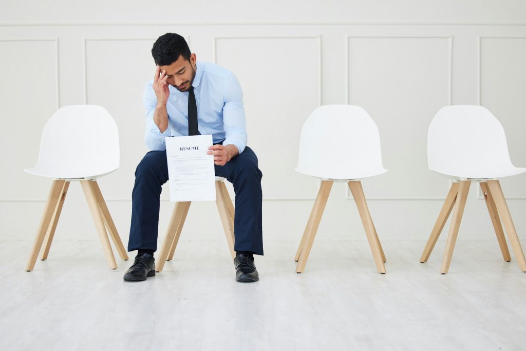 Stressed Applicant Sitting, With Him A Resume With A Lot Of Mistakes