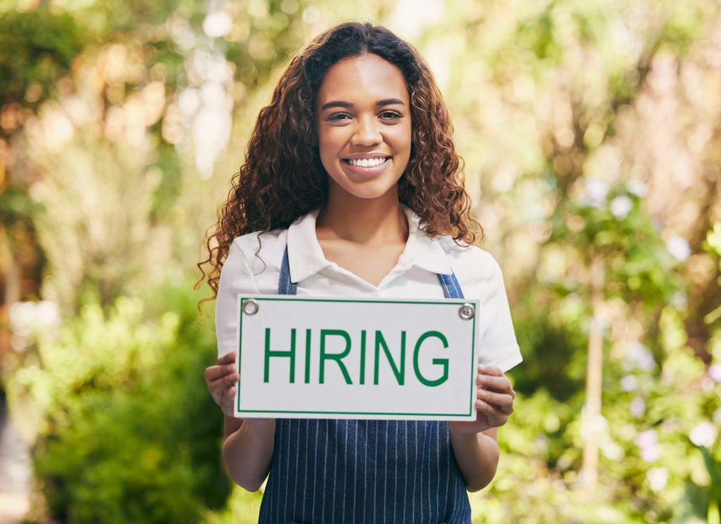 Shot Of A Florist Holding A Sign Looking For New Skill Base Hires.