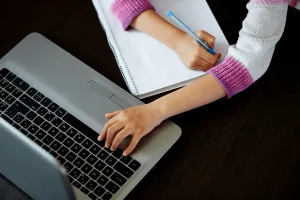 professional writer drafting contents using her laptop and notepad