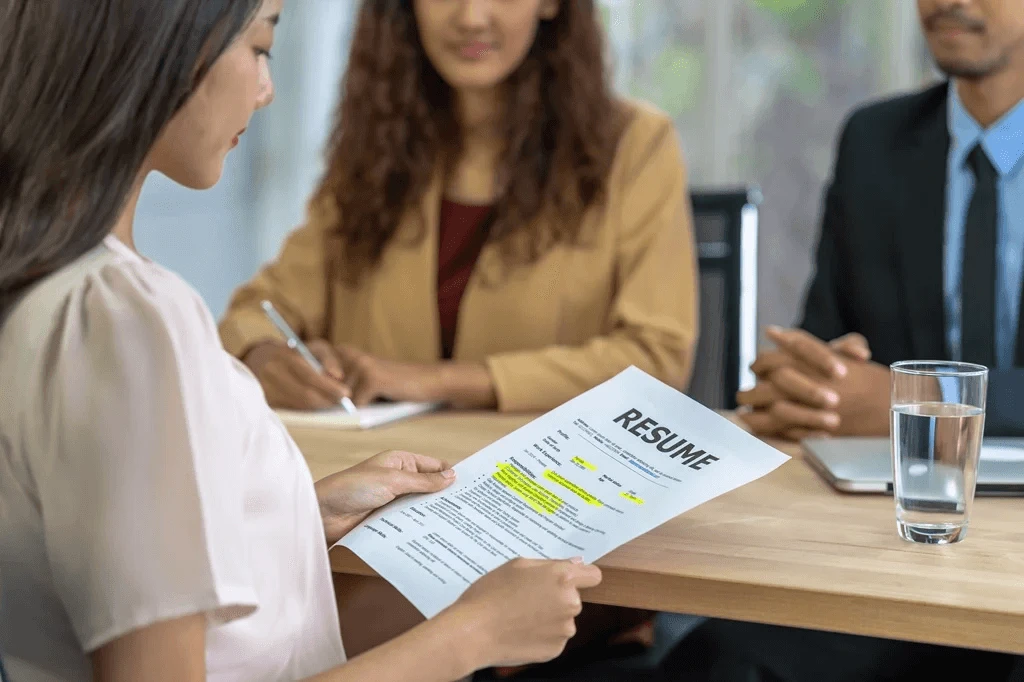 Job Applicant Submitting Her Resume To The Hiring Managers