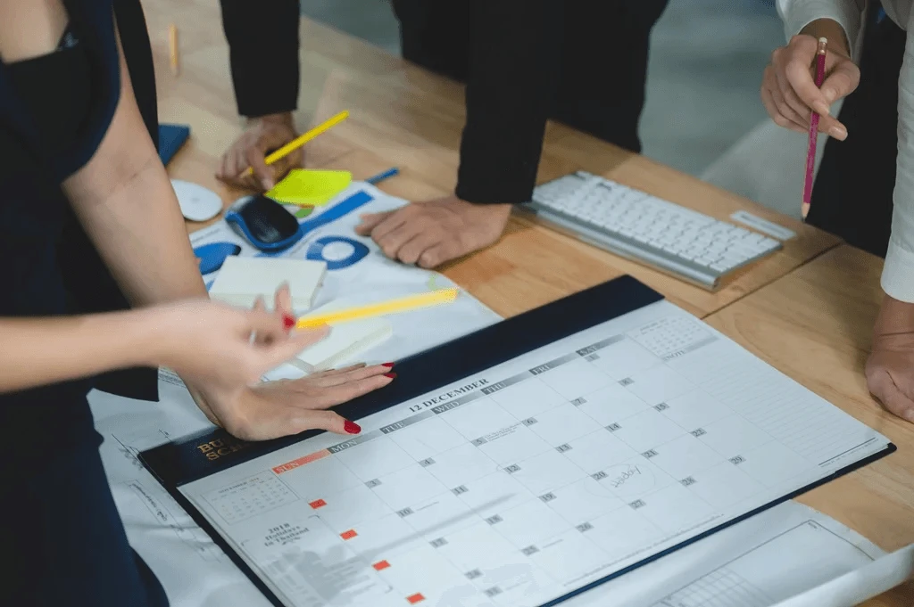 Team Of Employees Discussing Their Work Schedule Plans