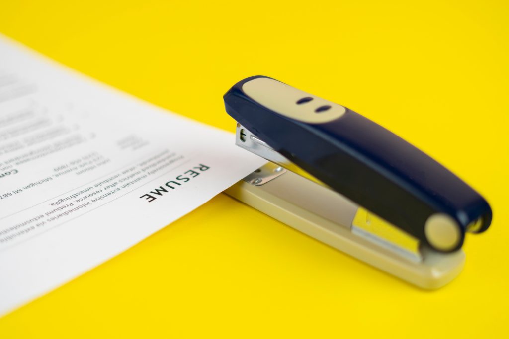 A Stapler And The Documents Files In Office On The Table, Staple The Paper Sheets Of Resume And Cont