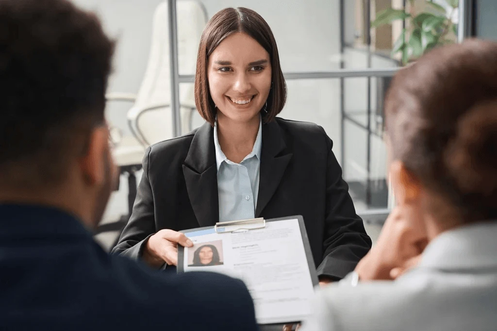 Applicant Submitting Her Resume To The Hiring Managers