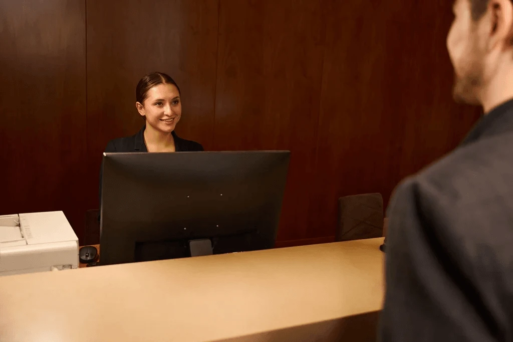 Receptionist Welcoming Visitor At Hotel