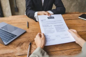 job applicant handing over his resume in an interview