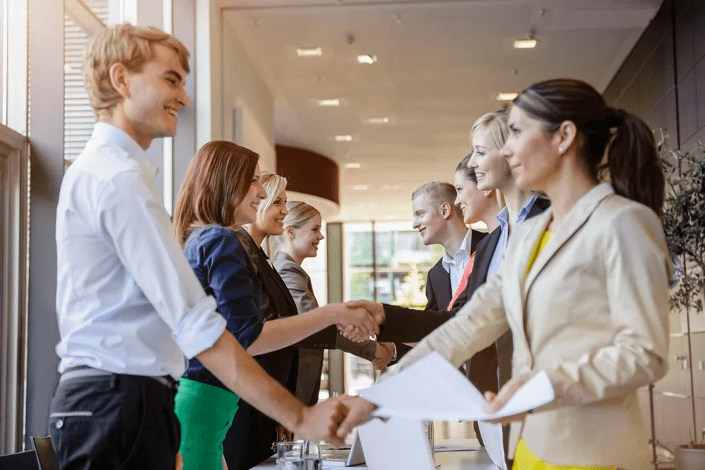 Newly Hired Job Seekers Exchanging Handshakes With Recruiters At A Job Fair