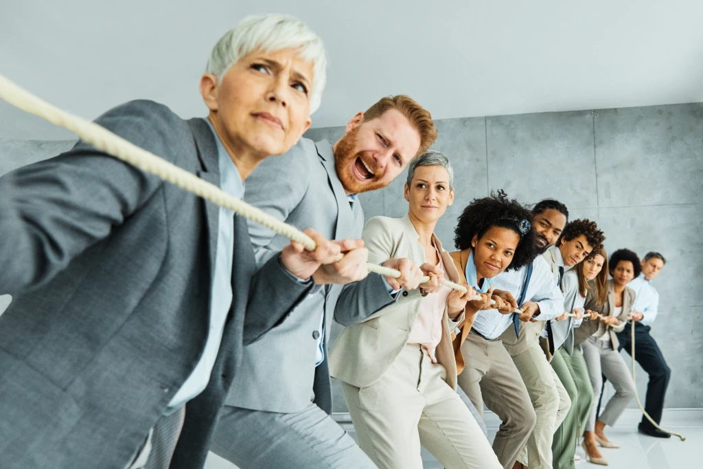 Businessman And Businesswoman In Office Tug Of War Competition Symbolizing Strength And Rivalry