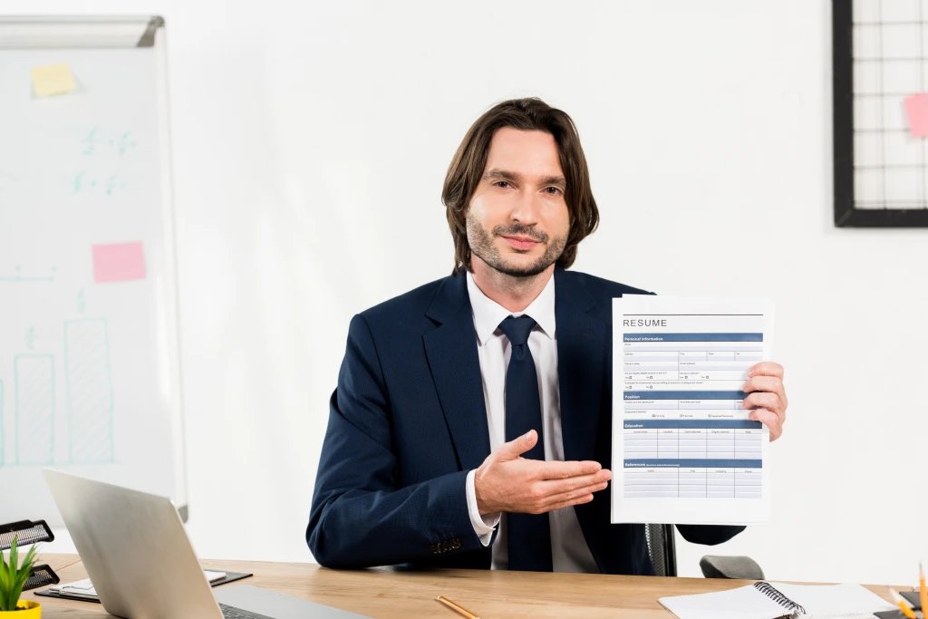 Handsome Recruiter Gesturing While Holding Resume