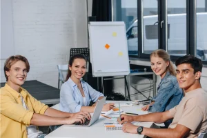 Smiling Team Of Businesspeople Looking At Camera