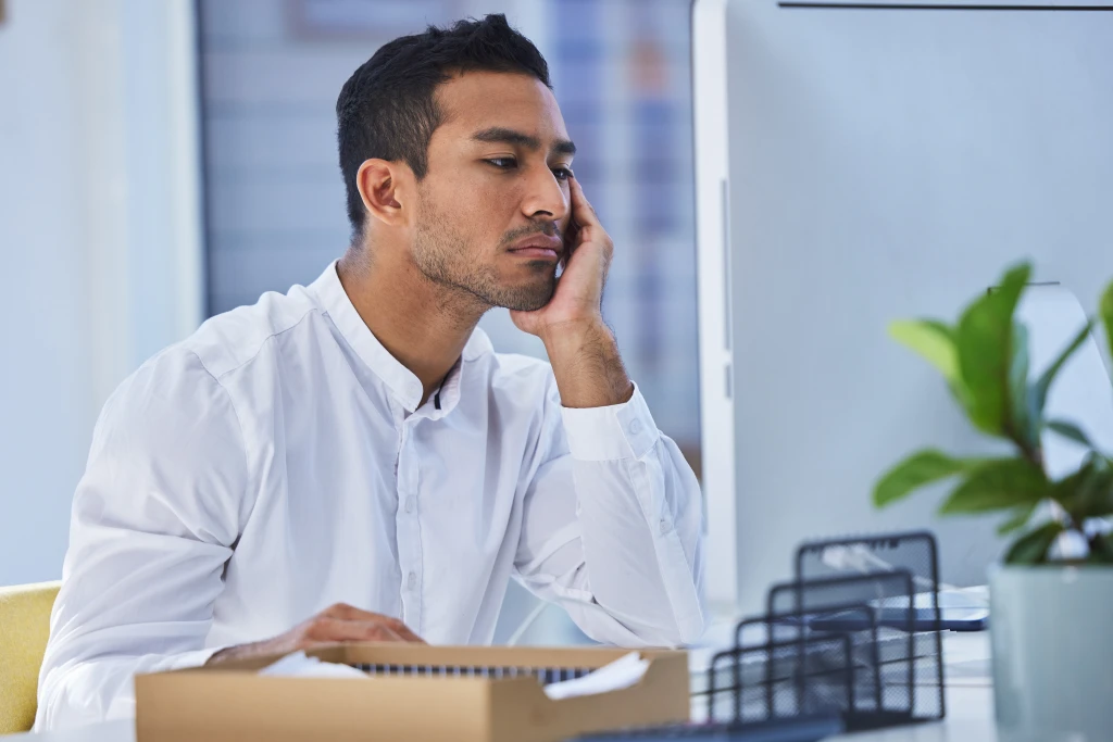 Businessman Sits At His Desk Appearing Disengaged And Uninterested Signs That Indicate Quiet Quitting