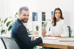 investor holding dollar banknotes and advisor looking at it