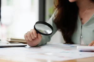 portrait of female looking through magnifying glass