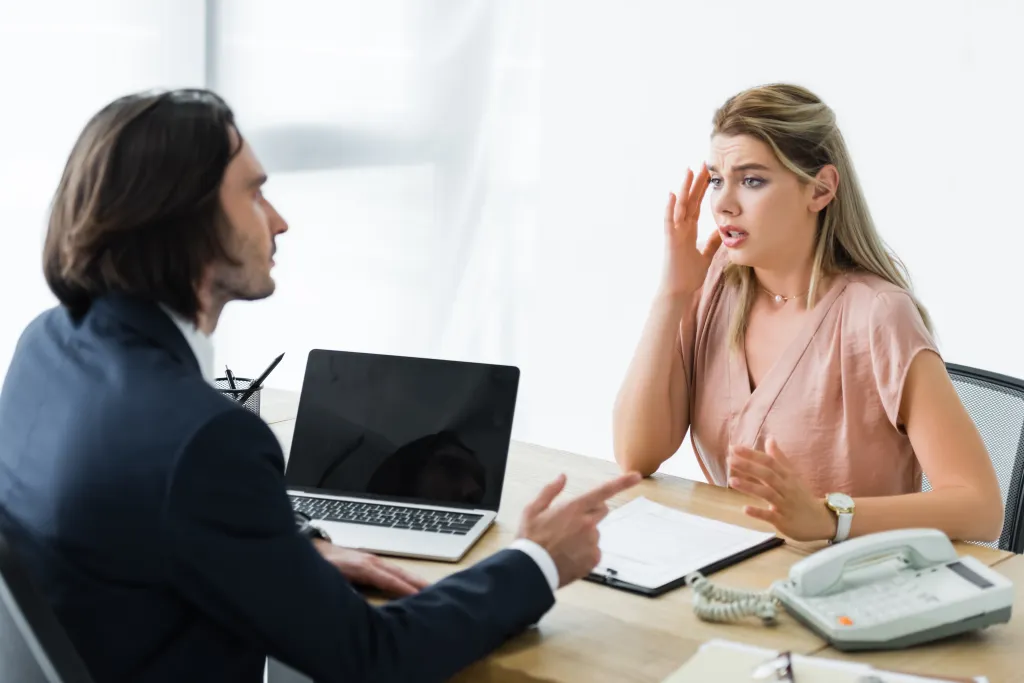 Upset Woman Sitting In Office And Talking With Businessman